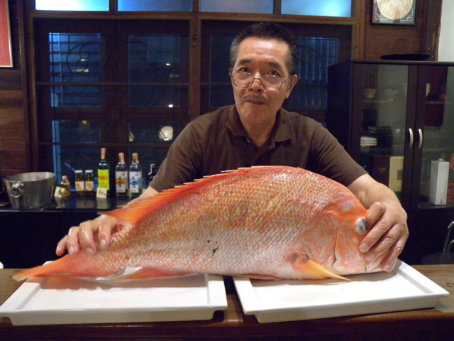 Japanese restaurant owner ready to cut the fish to slices